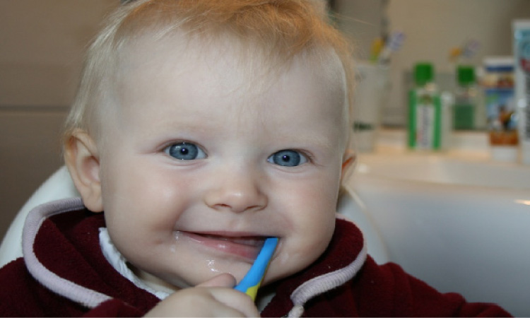 blue eyed baby boy brushing his teeth