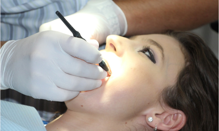 girl getting her teeth cleaned to remove plaque