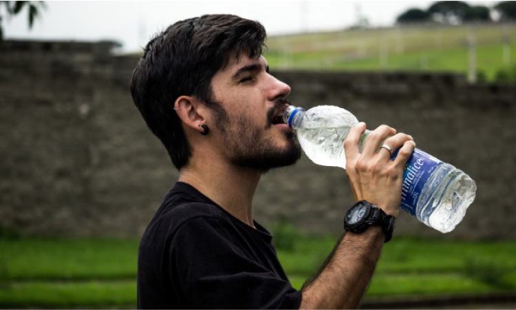 man drinking from a water bottle
