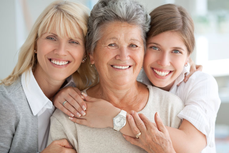 Three generations of smiling women with Cerec crowns